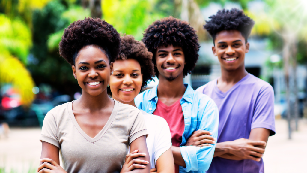 Four beautiful African American teenage siblings outside.